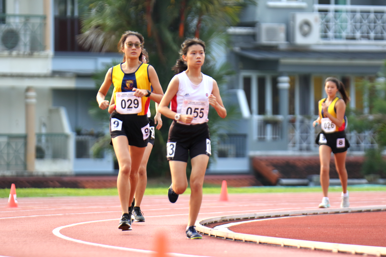 2 female runners mid-run at an outdoor track
